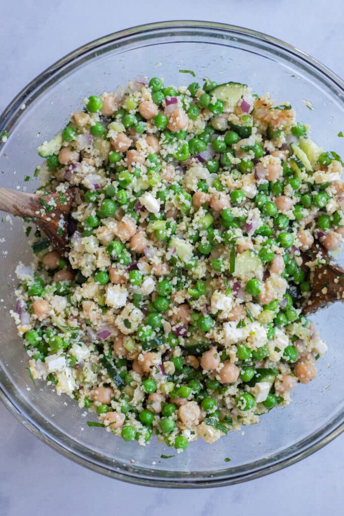 sweet pea and couscous salad all mixed together in a bowl