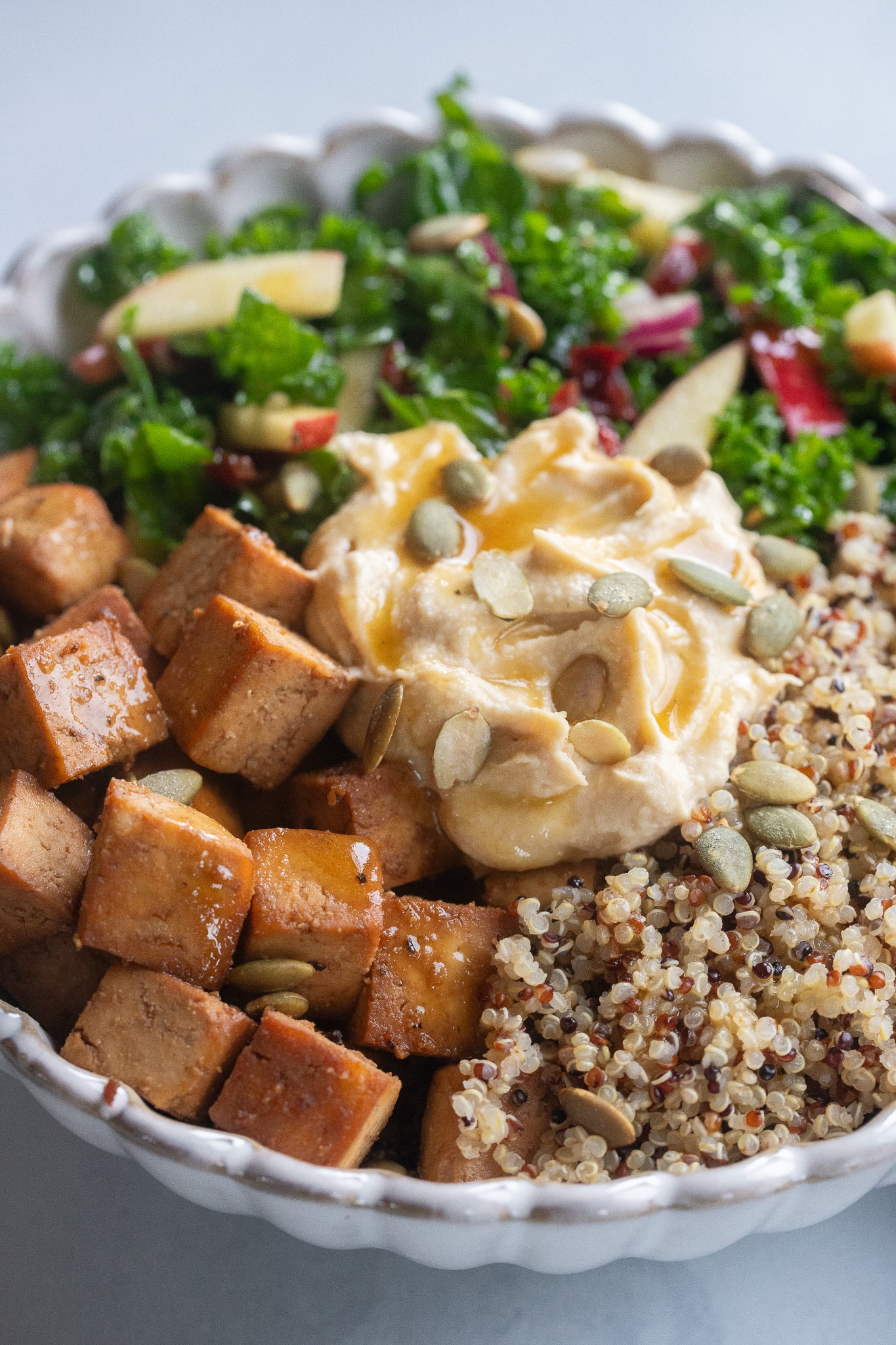 close up of a fall inspired quinoa power bowl with hummus and pumpkin seeds