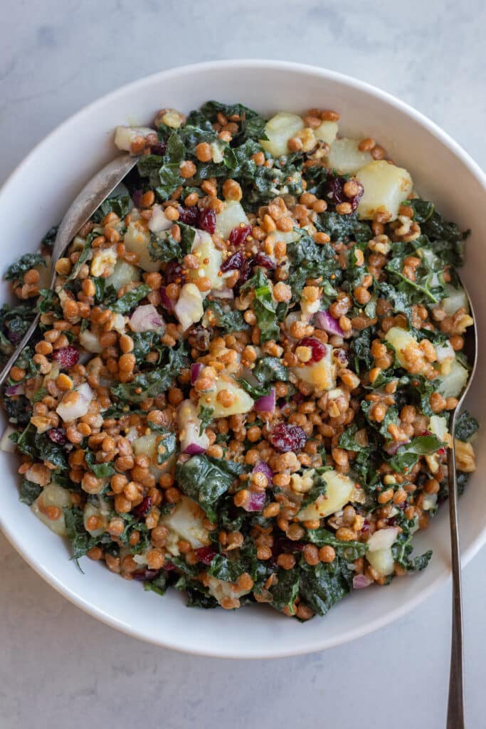 hearty kale salad in a serving bowl with a spoon