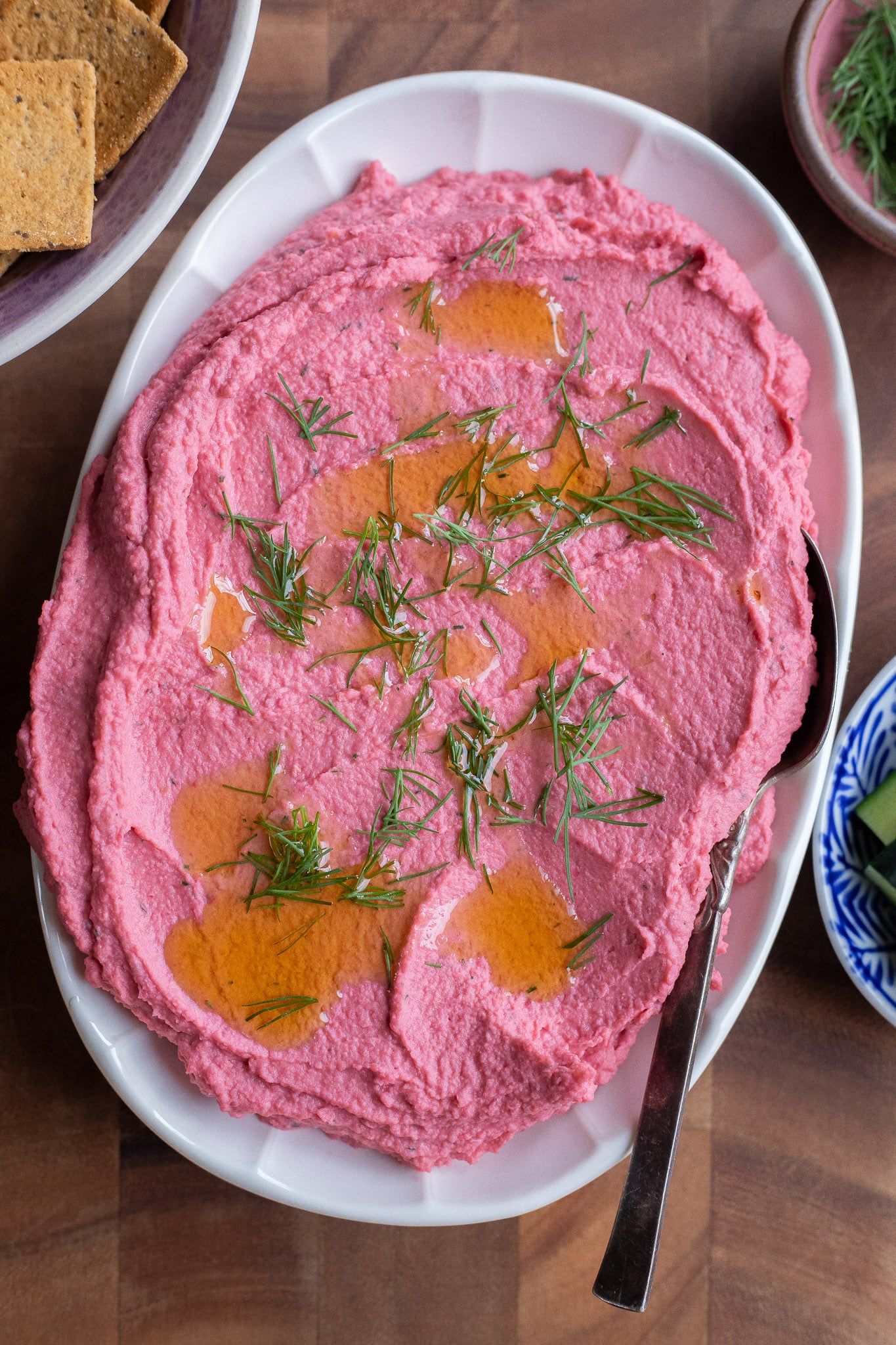 pickled beet hummus on a plate topped with fresh dill