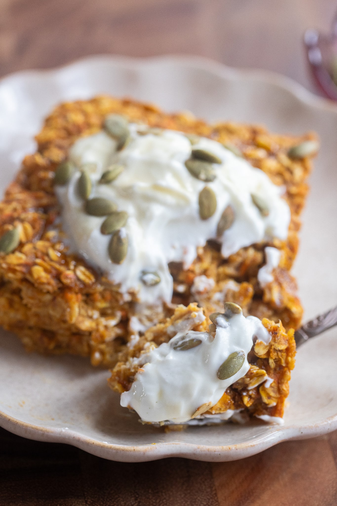 Close up of a slice of baked oatmeal with a fork and yogurt
