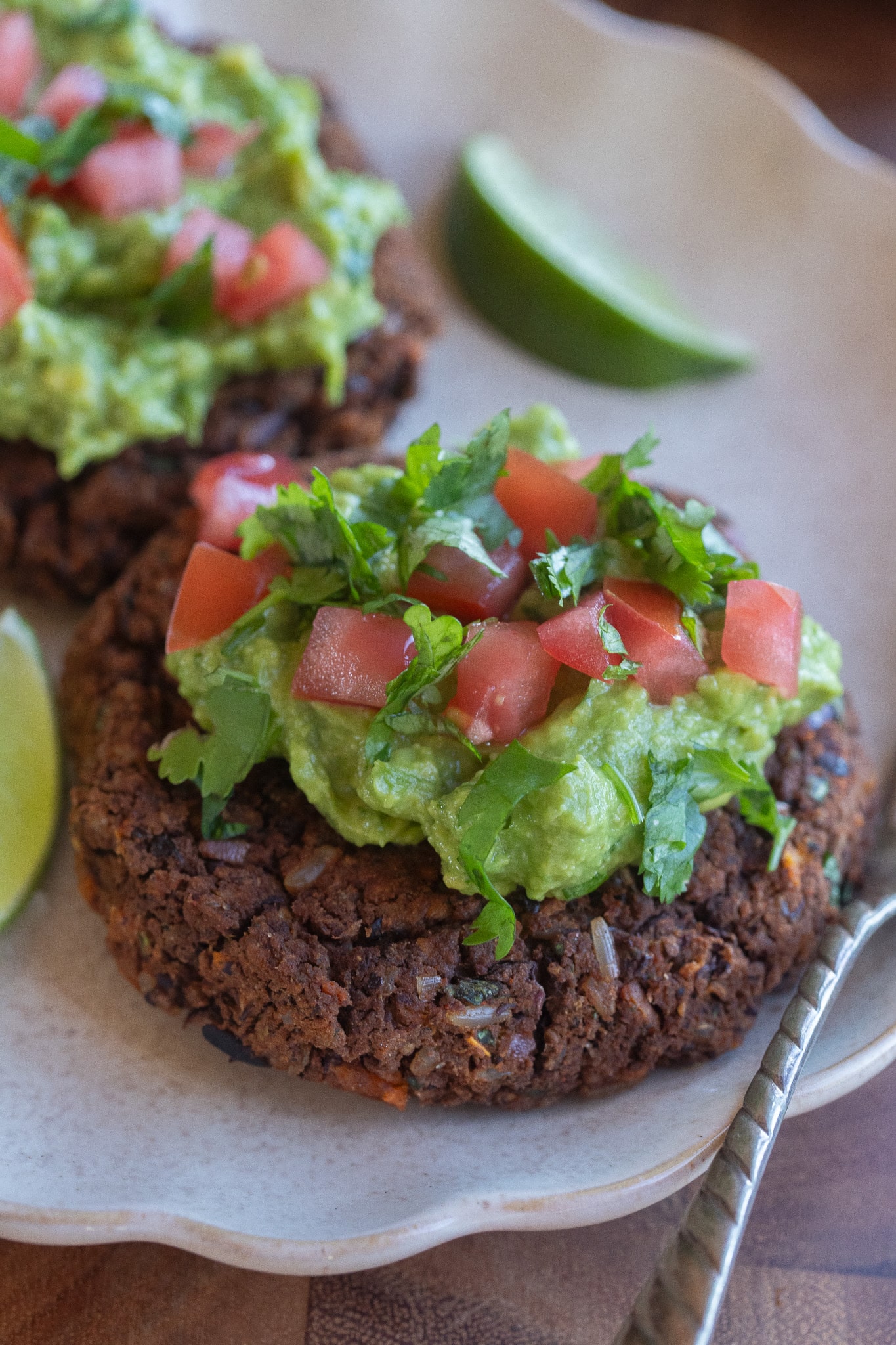 close up of a black bean sweet potato patty topped with guacamole